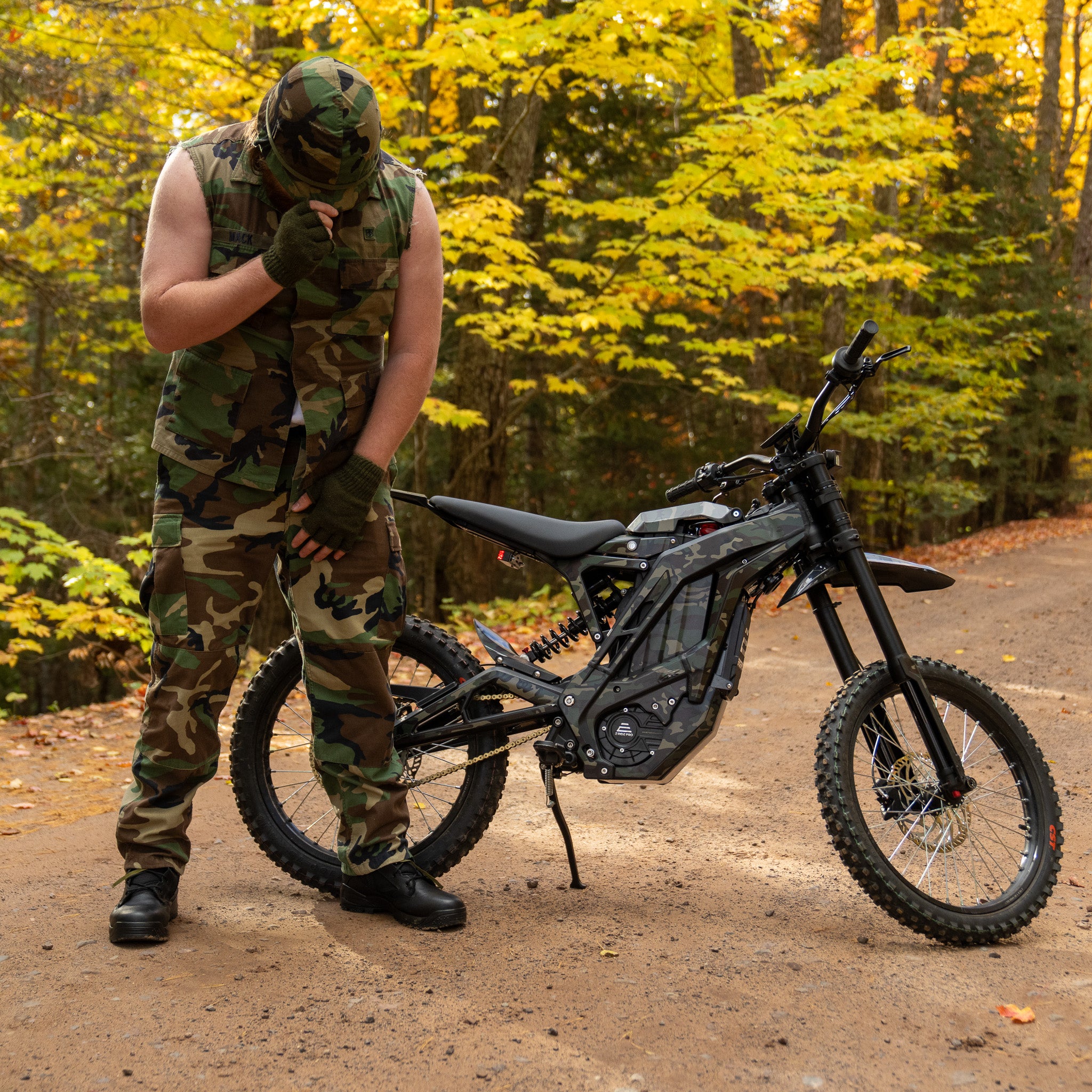 Camoflauged man bowing his head to an E Ride Pro SS 2.0 Electric Bike